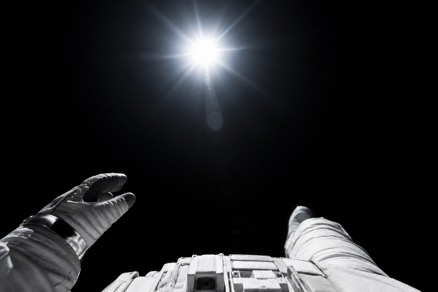 Astronaut viewing the Sun in space where it appears white against the blackness of the cosmos